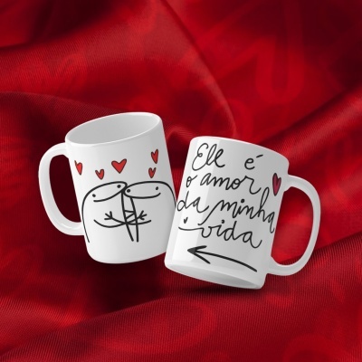 Duas canecas brancas com desenhos e texto em preto e vermelho sobre tecido vermelho