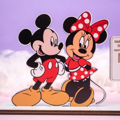 Estatueta de Mickey e Minnie Mouse em madeira com fundo lilás e nuvens