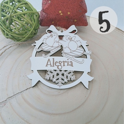 Enfeite decorativo branco com pássaros, bola verde e estrela vermelha na superfície clara