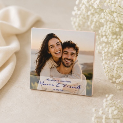 Fotografia impressa de um casal sorridente com texto azul em fundo bege e flores brancas