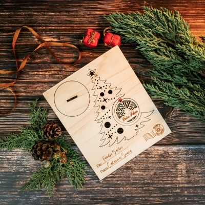 Caixa de madeira com decoração de Natal sobre mesa de madeira com pinhas e ramos verdes