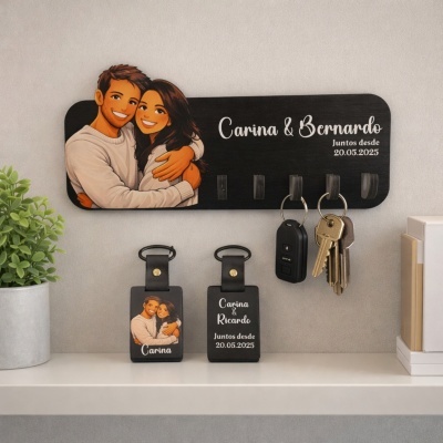 Suporte de chaves em madeira preta com ilustração de casal e texto personalizado, com portas-chaves na prateleira abaixo