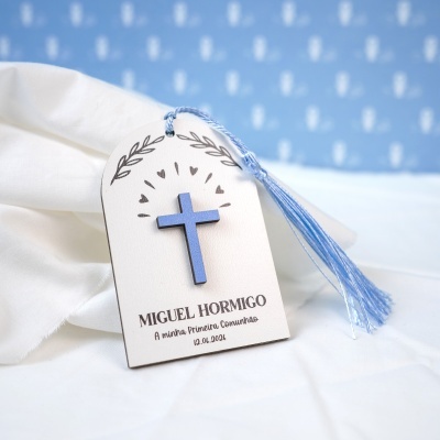 Etiqueta branca com cruz azul e tassel azul em pano branco com texto impresso.