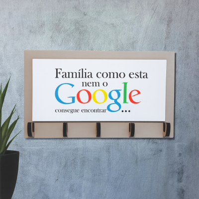 Cabide de madeira com placa escrita sobre família e Google, com cinco ganchos, pendurado numa parede cinza