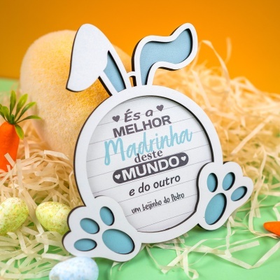 Placa decorativa em forma de coelho com texto para madrinha, fundo laranja e verde com decoração de páscoa