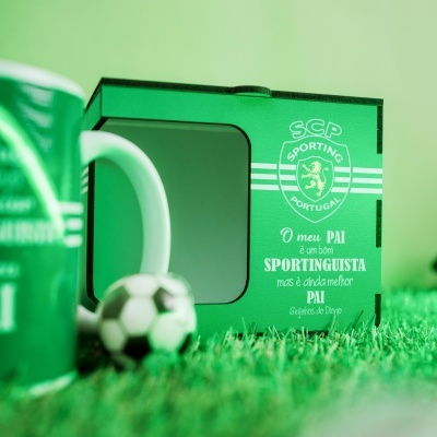 Caixa verde com logótipo do Sporting e texto dedicado ao pai, com caneca e bola de futebol em relva artificial.