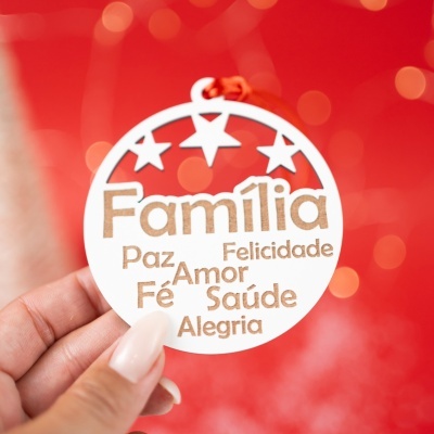 Ornamento pendente branco com palavras cortadas em castanho sobre fundo vermelho