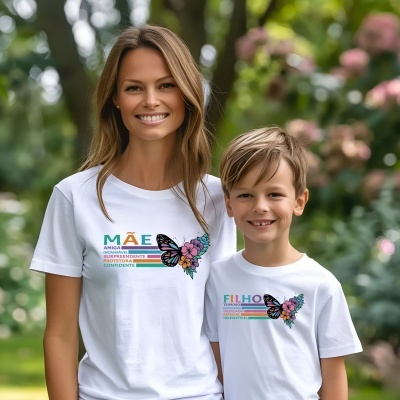 Duas t-shirts brancas com estampas coloridas e textos sobre mãe e filho, em ambiente de parque.