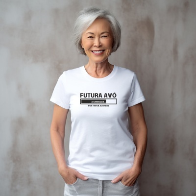Mulher idosa sorridente com t-shirt branca onde está escrito FUTURA AVÓ.