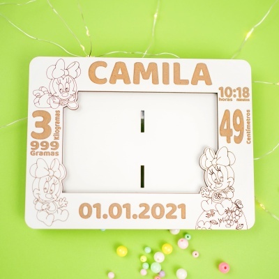 Moldura branca com nome Camila, desenhos Minnie e texto em madeira sobre fundo verde.