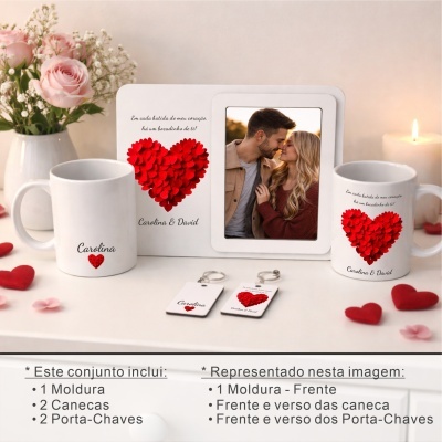 Conjunto de presente com moldura branca, canecas e porta-chaves com coração vermelho e texto em português num ambiente com flores e vela.