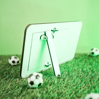 Parte traseira de moldura branca com suporte em relva artificial e mini bolas de futebol