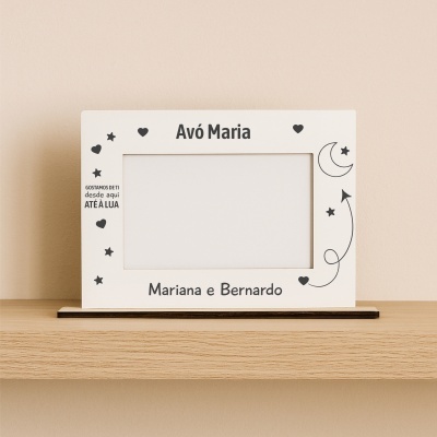 Moldura branca com texto e desenhos em preto sobre prateleira de madeira
