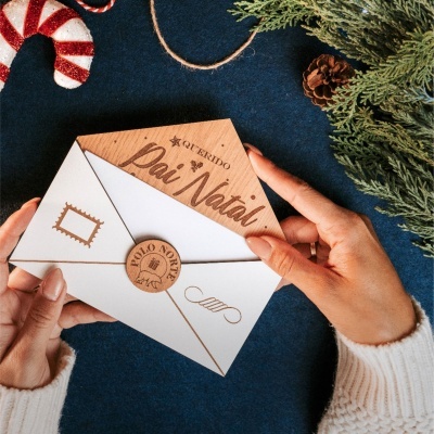Envelope branco com cartão de madeira escrito Querido Pai Natal e decoração natalícia