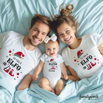 Família com camisolas e body de bebé brancos com estampados natalícios em letras pretas, vermelhas e verdes, sobre lençóis azuis.