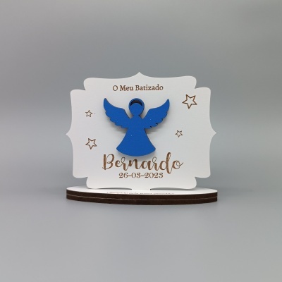 Placa decorativa branca com anjo azul e texto de batizado em português.