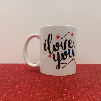 Caneca branca com texto decorativo e corações vermelhos.