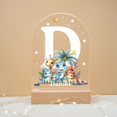 Luminária de acrílico com base de madeira, letra D em branco, dinossauros coloridos e nome Daniel.