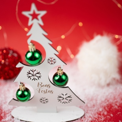 Decoração de Natal em forma de árvore branca com bolas verdes e texto Boas Festas