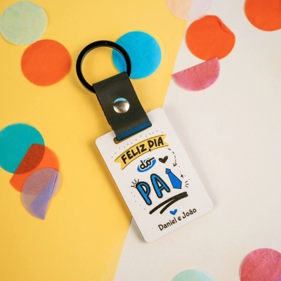 Porta-chaves com cartão de feliz dia do pai e confetes coloridos no fundo