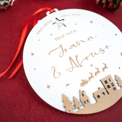 Ornamento de Natal redondo branco com fita vermelha e texto dourado