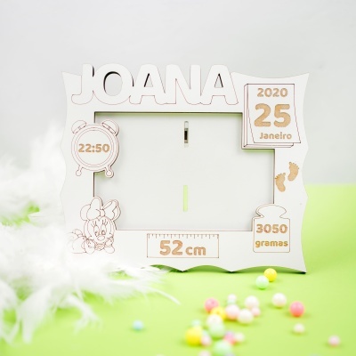 Moldura de madeira branca personalizada com nome e dados de nascimento num fundo verde