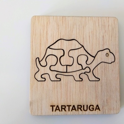 Puzzle de madeira em forma de tartaruga com contorno preto e texto TARTARUGA