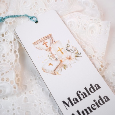 Etiqueta decorativa com tema religioso sobre tecido branco rendado
