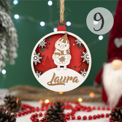 Enfeite de Natal em madeira com desenho de pinguim e nome Laura.