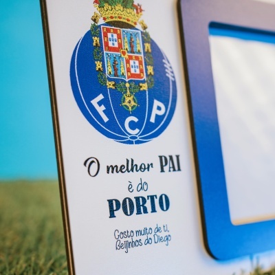 Placa branca com escudo azul e texto em português.