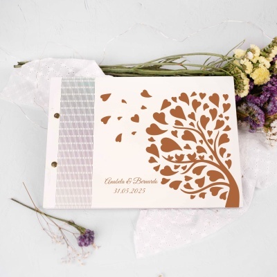 Livro branco com desenho de árvore de corações castanhos e texto personalizados, rodeado por flores secas