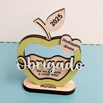 Objeto decorativo de madeira em forma de maçã com textos de agradecimento a professora