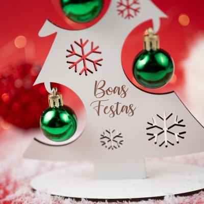 Árvore de Natal branca em madeira com bolas verdes e texto Boas Festas