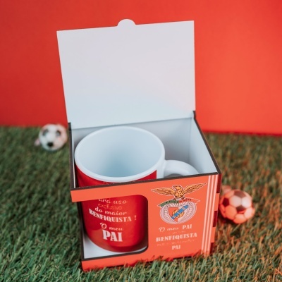 Caneca vermelha do SL Benfica na embalagem em fundo de relva sintética com bolas de futebol