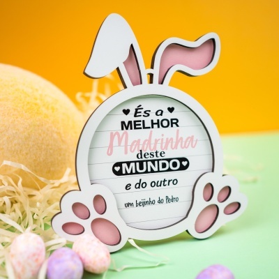 Placa decorativa em forma de coelho com texto em português e fundo colorido.
