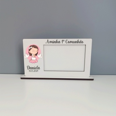 Moldura branca com ilustração de menina e texto alusivo à primeira comunhão em fundo cinzento