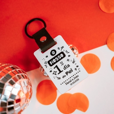 Chaveiro com etiqueta branca de texto sobre fundo vermelho e pontos laranja