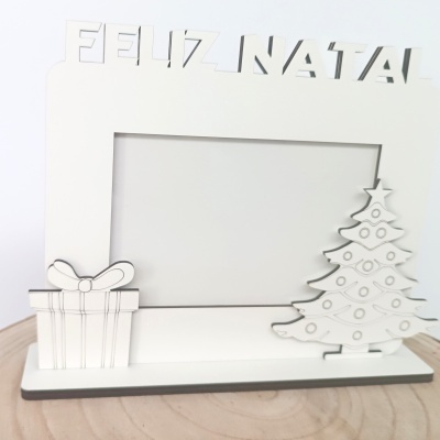 Moldura branca em madeira com texto FELIZ NATAL e decorações natalícias