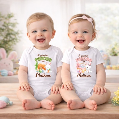 Dois bebés sorridentes com bodies de algodão branco decorados para a Páscoa, sentados em madeira clara com fundo desfocado
