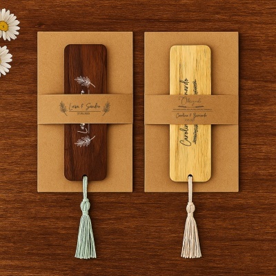 Dois marcadores de livros de madeira, escura e clara, com tassel e texto personalizado em cartão marrom.