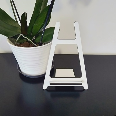 Suporte branco para telemóvel com planta em vaso branco ao lado