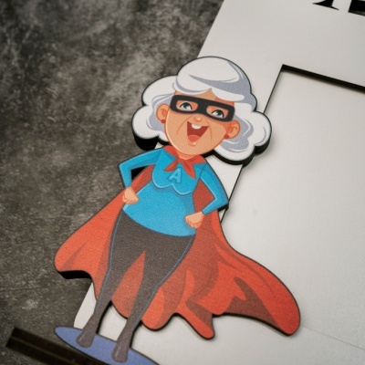 Moldura branca com desenho de senhora idosa de super-heroína com capa vermelha.