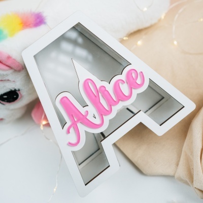 Espelho decorativo branco em forma de casa com texto rosa Athlete e peluche colorido ao lado