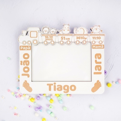 Moldura de madeira branca com desenhos de trem e animais e texto decorativo, sobre fundo branco com contas coloridas.