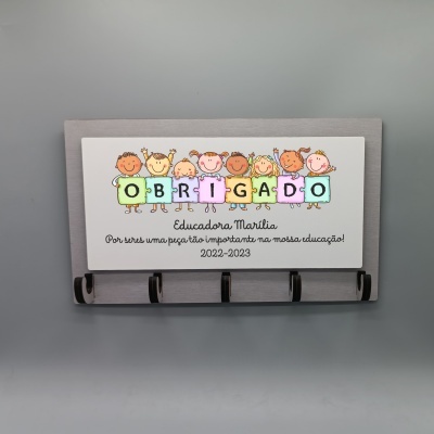 Placa decorativa com crianças em peças de puzzle coloridas e agradecimento para Educadora Marília