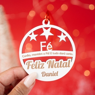 Etiqueta circular de Natal branca com estrelas e texto em castanho num fundo vermelho