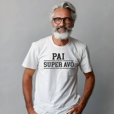 Homem com óculos e barba grisalha usa t-shirt branca com texto em preto PAI DESDE 1980 SUPER AVÔ DESDE 2025