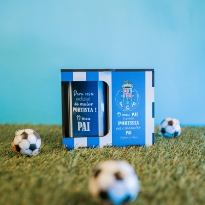 Caixa azul e branca com texto em português e bolas de futebol no relvado