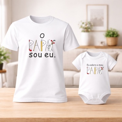 Conjunto t-shirt branca adulto e body branco bebé com texto e ilustrações coloridas em ambiente doméstico.