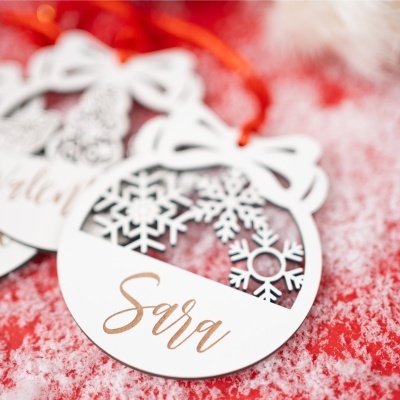 Etiqueta de papel branca com corte decorativo de floco de neve e cordão vermelho